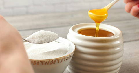 a jar and a bowl of honey and sugar to show advantages to honey over sugar