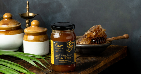 Himalayan wild honey from honey and spice beside a honey comb