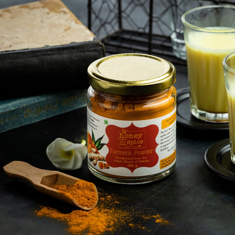 Authentic turmeric powder jar with full of spoon or golden milk