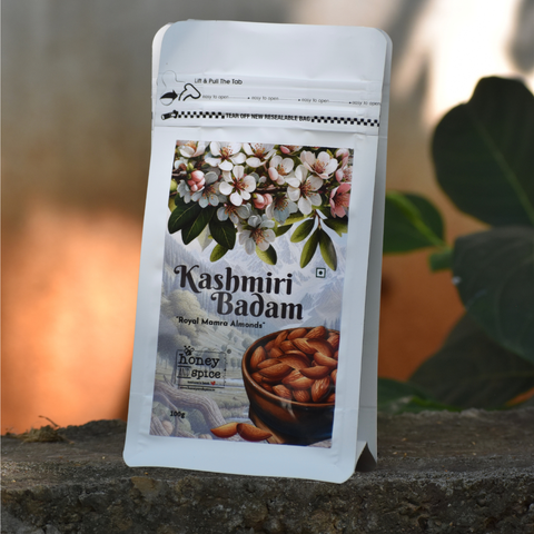 Angled front view of Kashmiri Badam pack – Royal Mamra almonds with leafy garden backdrop.