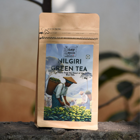 Nilgiri Green Tea pack on stone surface with blurred greenery – Premium single estate tea from the Blue Hills.