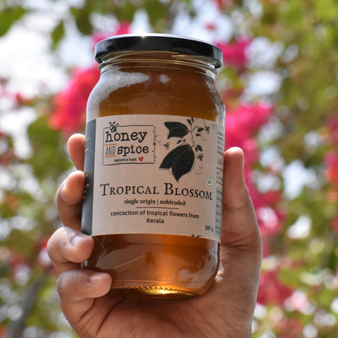 Hand holding Tropical Blossom honey jar in outdoors