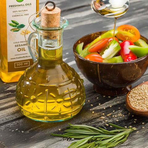 Sesame Oil bottle styled with fresh vegetables, a glass jug, and sesame seeds for a rustic kitchen vibe.