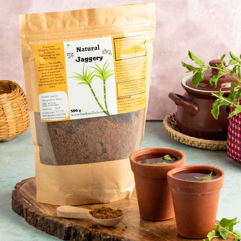 Natural Jaggery pouch placed with clay pot cups and wooden tray – Rustic and traditional kitchen setup.