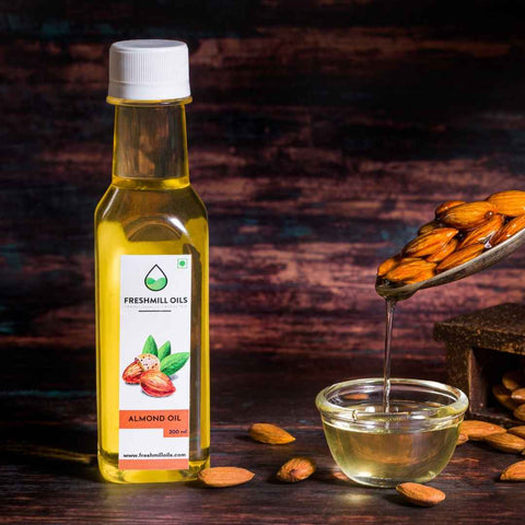 Almond oil bottle of 200 ml with raw almonds and oil in glass bowl