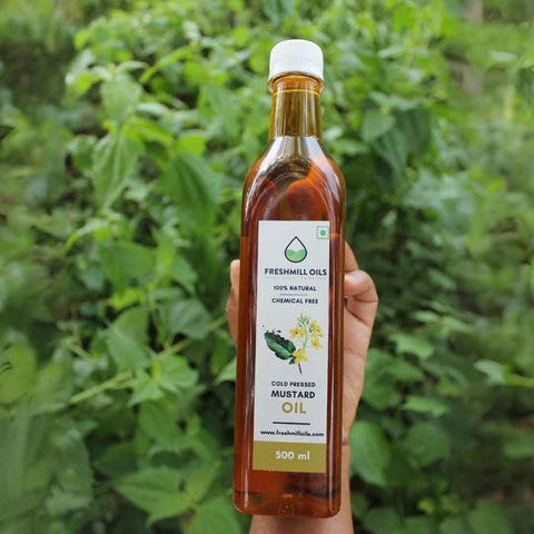 Hand holding Cold Pressed Mustard oil bottle of 500 ml