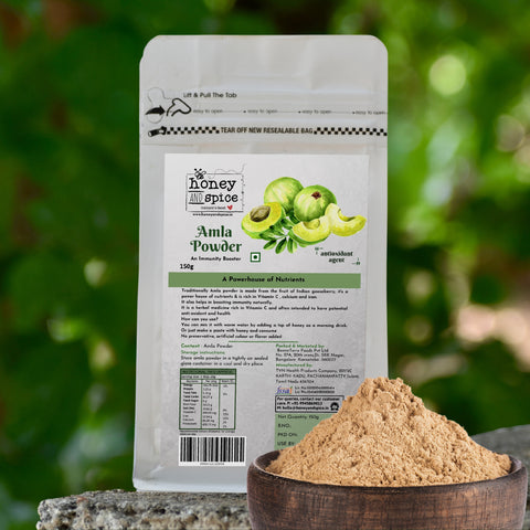 Packaging of Amla Powder with a bowl of powder in front, against a green leafy background.