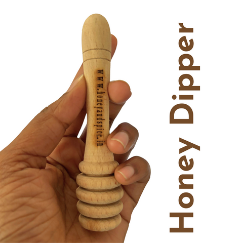 Wooden honey dipper held in hand, engraved with branding, perfect for drizzling honey with precision.