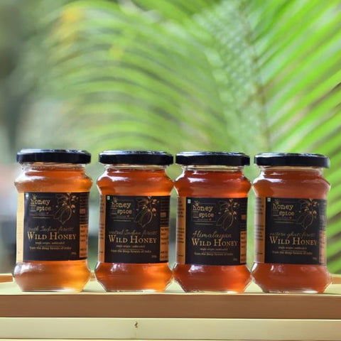 Front view of 4 wild honey jars with black labels from Indian forests and Himalayas