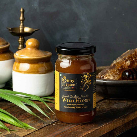 Styled image of Wild Honey jar with natural props and honey dipper
