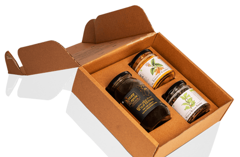 Gift set showcasing three premium jars of wild honey, black pepper, and turmeric inside an eco-friendly box.